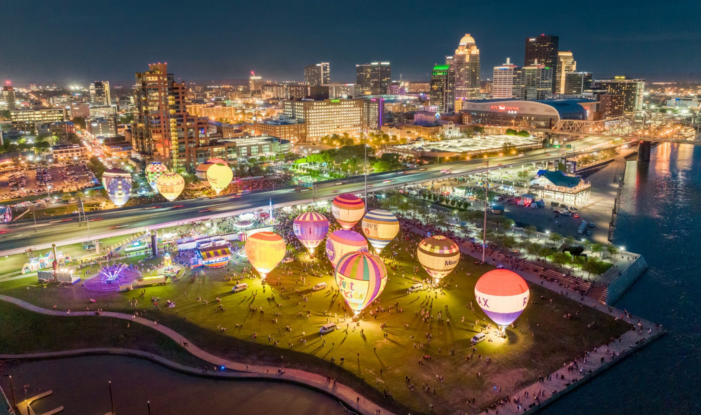 Overlook of Waterfront Park's Great Lawn with a showcase of glowing hot air balloons